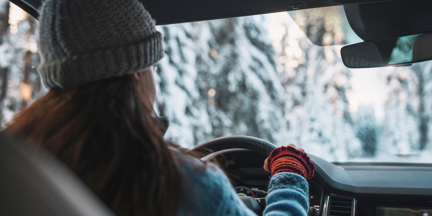 Image of a woman driving down a winter road
